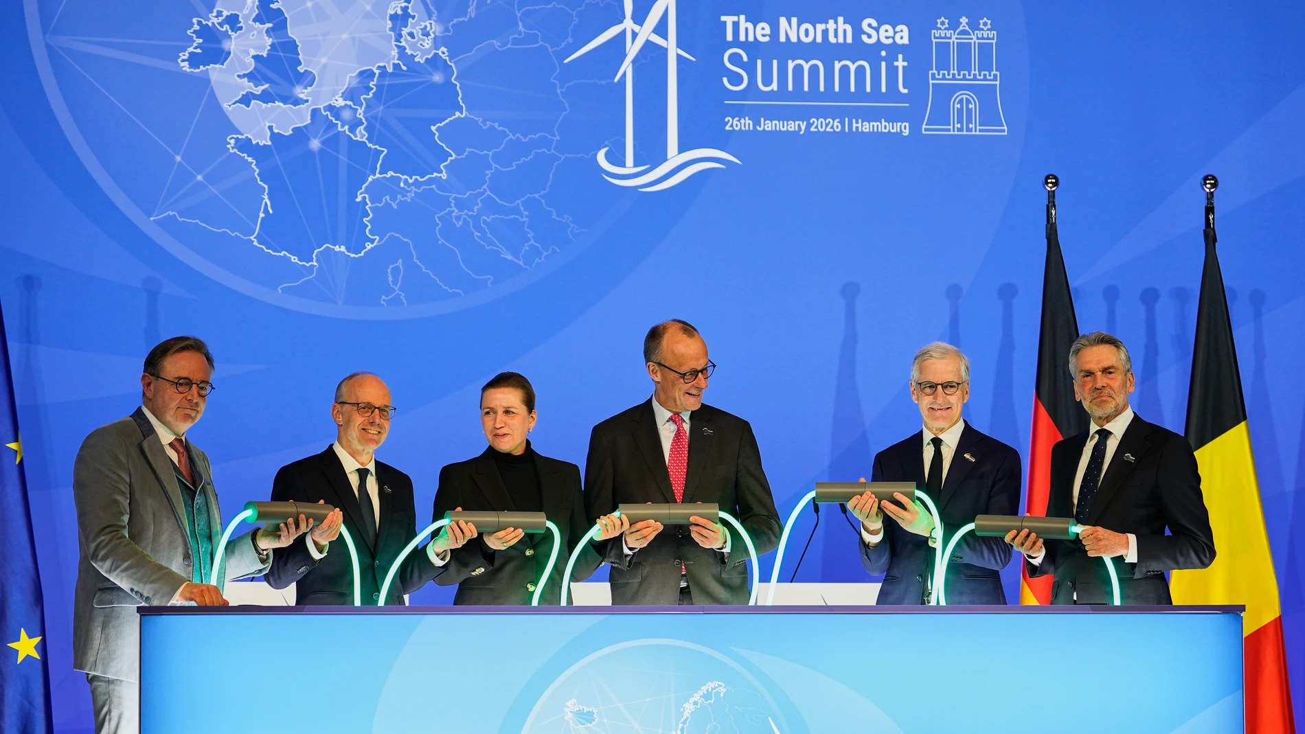 Belgian Prime Minister Bart de Wever, Luxembourg Prime Minister Luc Frieden, Danish Prime Minister Mette Frederiksen, German Chancellor Friedrich Merz, Norway Prime Minister Jonas Gahr, and Dutch Prime Minister Dick Schoof, from left, hold a light connection during the North Sea Summit in Hamburg, Germany, where the North Sea coastal states aim to strengthen cross-border cooperation in the expansion of offshore wind energy and hydrogen infrastructure on Monday, January 26, 2026. (AP Photo/Mar...