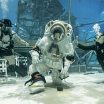 La astronauta de la NASA Loral O'Hara se arrodilla para recoger una piedra durante las pruebas del traje espacial lunar de Axiom en el Laboratorio de Flotabilidad Neutral de la NASA en Houston el 24 de septiembre de 2025.