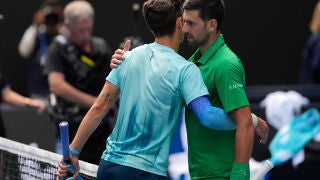 Lorenzo Musetti, left, of Italy embraces Novak Djokovic of Serbia after retiring from their quarterfinal match at the Australian Open tennis championship in Melbourne, Australia, Wednesday, Jan. 28, 2026. (AP Photo/Asanka Brendon Ratnayake)