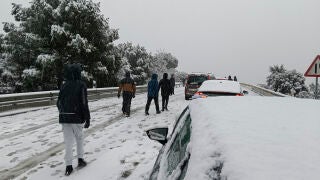GALAPAGAR(MADRID), 28/01/2026.- Una persona camina junto a varios veh&iacute;culos en la carretera M-519 a la altura de Galapagar, este mi&eacute;rcoles. El temporal de fr&iacute;o, lluvia y nieve que atraviesa estos d&iacute;as la pen&iacute;nsula mantiene afectados todos los puertos en la Comunidad Madrid por la nieve. Es necesario el uso de cadenas o neum&aacute;ticos de invierno en todos los puertos de la Comunidad y en desde el kil&oacute;metro 13 de la A-6. EFE/&Aacute;lvaro Blanco 