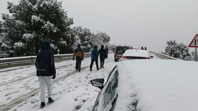 GALAPAGAR(MADRID), 28/01/2026.- Una persona camina junto a varios veh&iacute;culos en la carretera M-519 a la altura de Galapagar, este mi&eacute;rcoles. El temporal de fr&iacute;o, lluvia y nieve que atraviesa estos d&iacute;as la pen&iacute;nsula mantiene afectados todos los puertos en la Comunidad Madrid por la nieve. Es necesario el uso de cadenas o neum&aacute;ticos de invierno en todos los puertos de la Comunidad y en desde el kil&oacute;metro 13 de la A-6. EFE/&Aacute;lvaro Blanco 