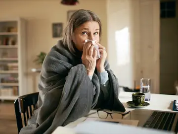 Una mujer tiene un escalofrío por la fiebre Una mujer tiene un escalofrío por la fiebre