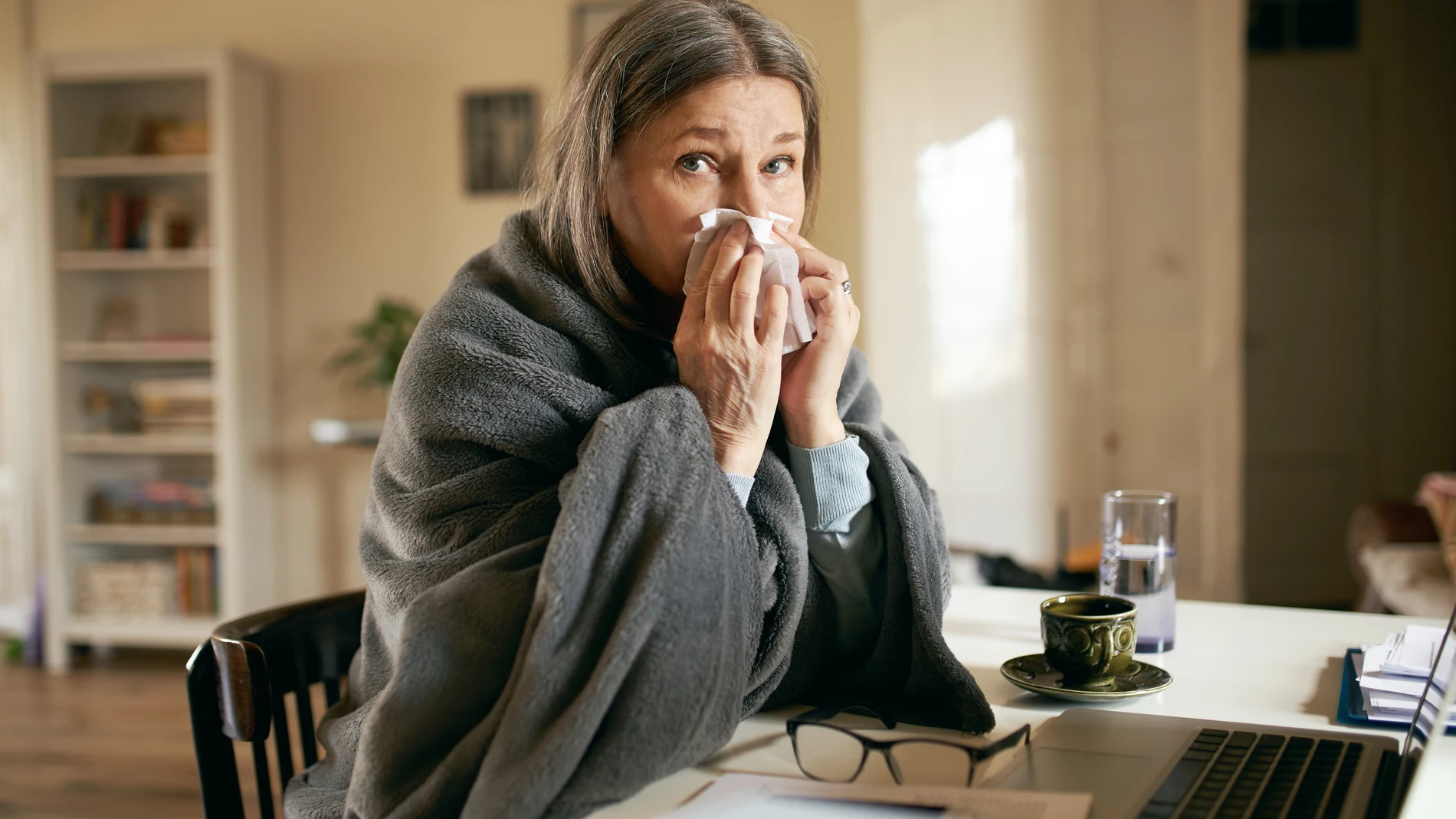 Una mujer tiene un escalofrío por la fiebre