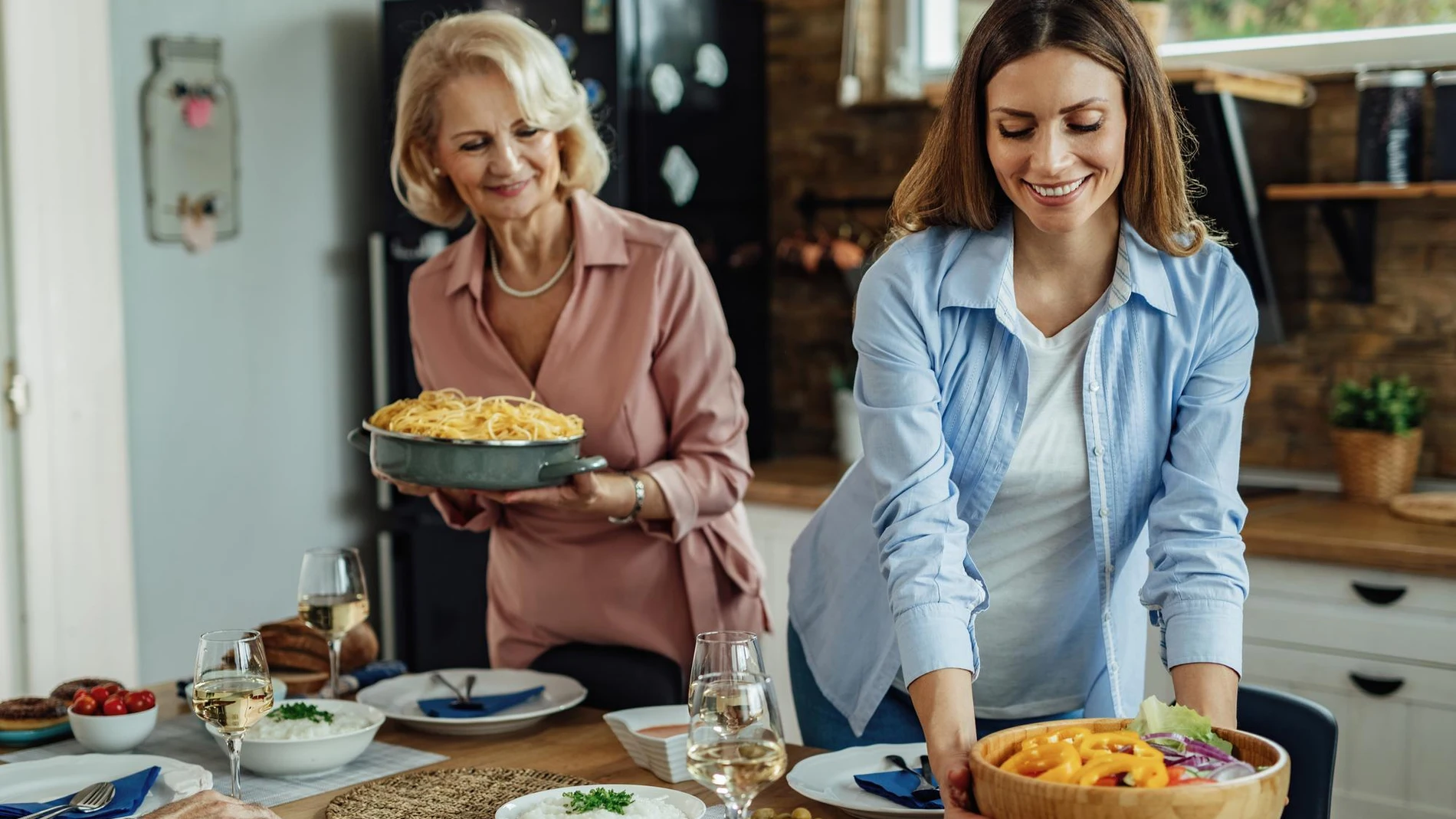 Mujeres colocan en la mesa alimentos típicos de la dieta mediterránea