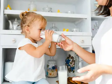 Bebé mayor bebiendo leche infantil en casa Madre alimenta a su bebé con un biberón en casa, en el contexto de la alerta sanitaria por la retirada de varias leches de fórmula infantiles por posible contaminación con la toxina cereulida