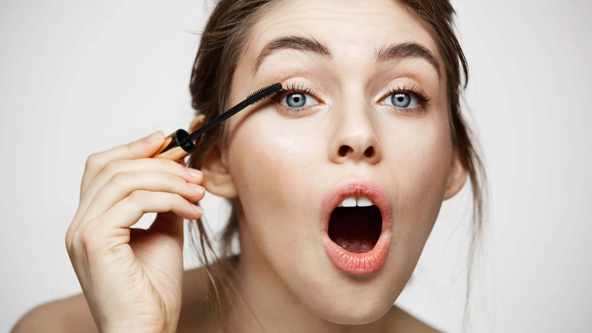 mujer aplicandose mascara de pestanas