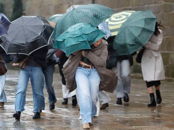 FOTODELD&Iacute;A SANTIAGO DE COMPOSTELA, 11/02/2025.- Varias personas se protegen de la lluvia, ese mi&eacute;rcoles en Santiago de Compostela. EFE/Lavandeira jr 