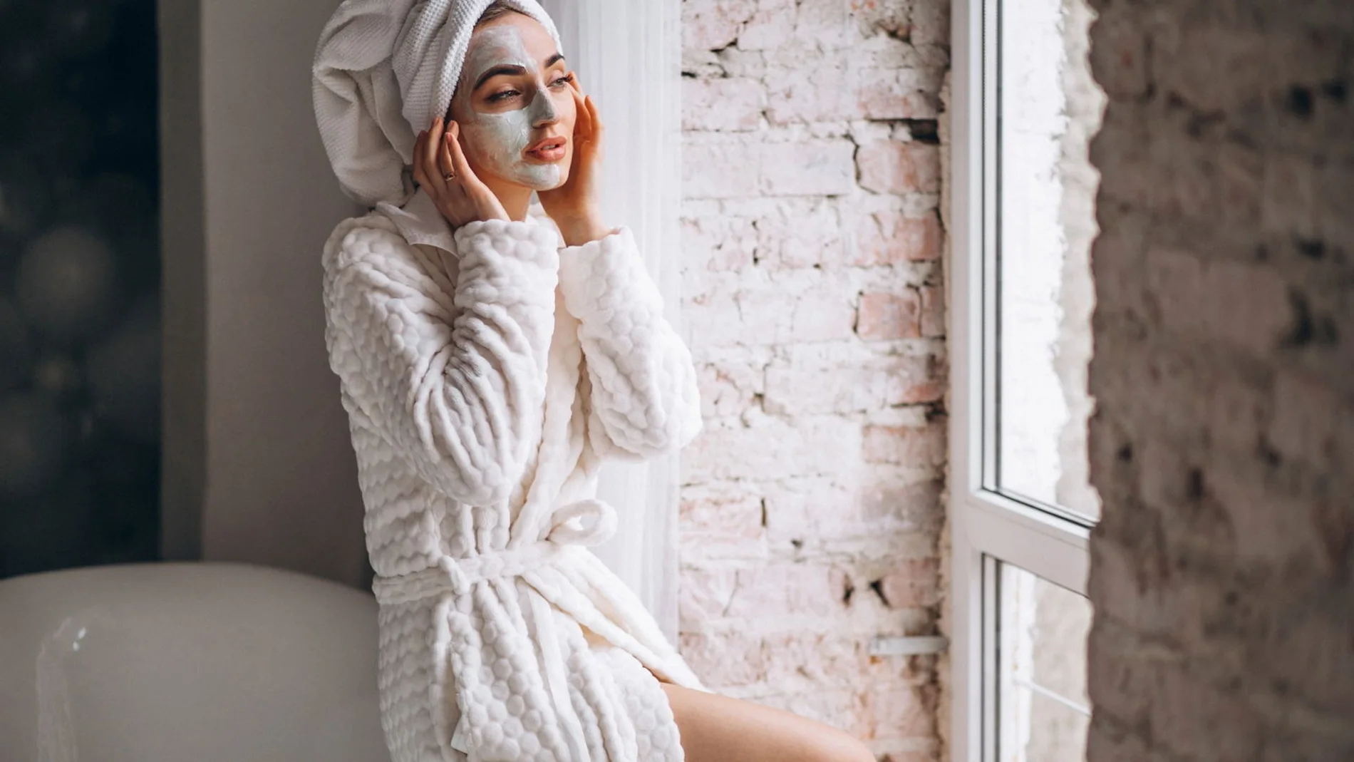 mujer aplicando facial maskin un bano