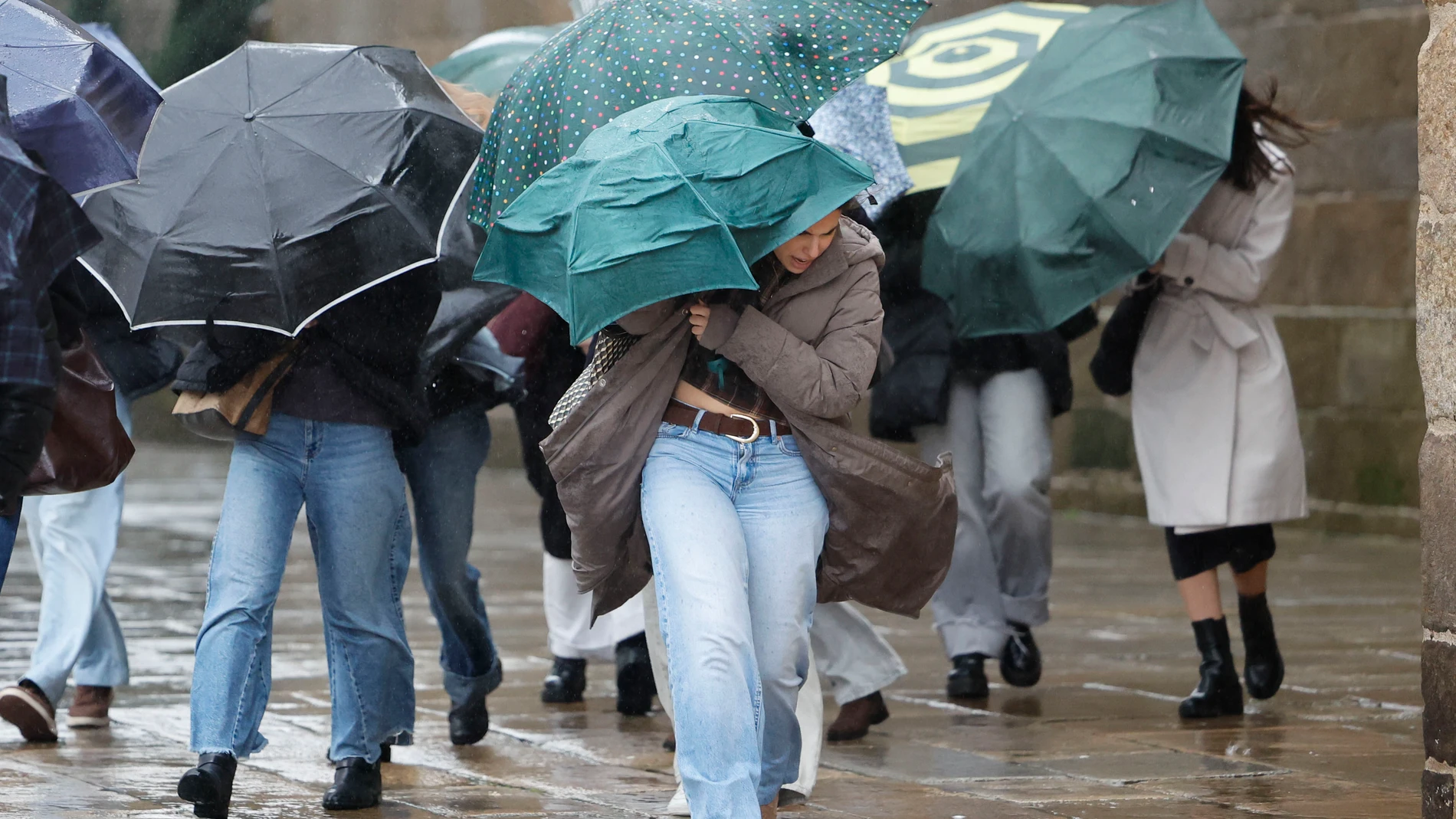 FOTODELDÍA SANTIAGO DE COMPOSTELA, 11/02/2025.- Varias personas se protegen de la lluvia, ese miércoles en Santiago de Compostela. EFE/Lavandeira jr