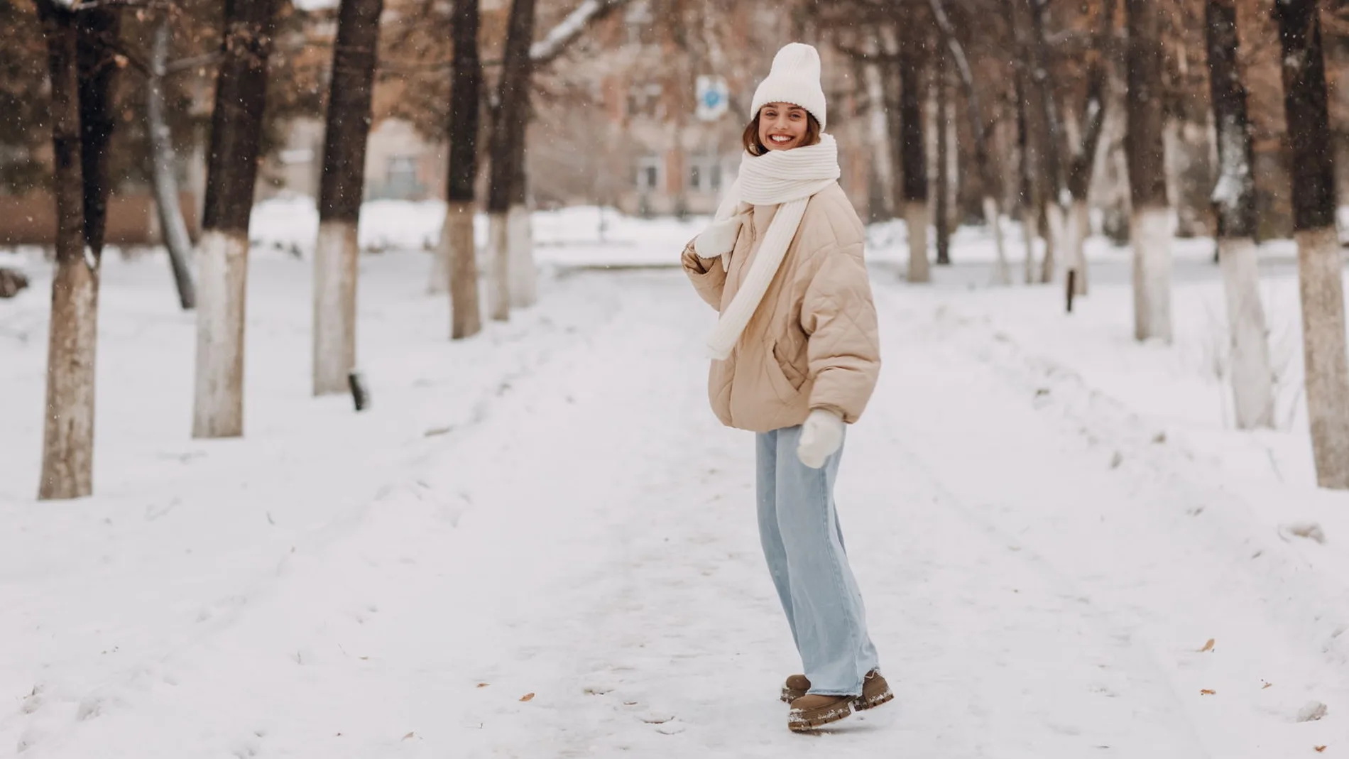 mujer caminando por un parque nevado con botas de invierno resistentes al frio y la lluvia