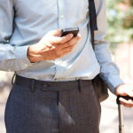 hombre de negocios sosteniendo telfono mvil y maleta