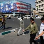 Iran&iacute;es pasean junto a un mural de propaganda contra EE UU en las calles de Teher&aacute;n