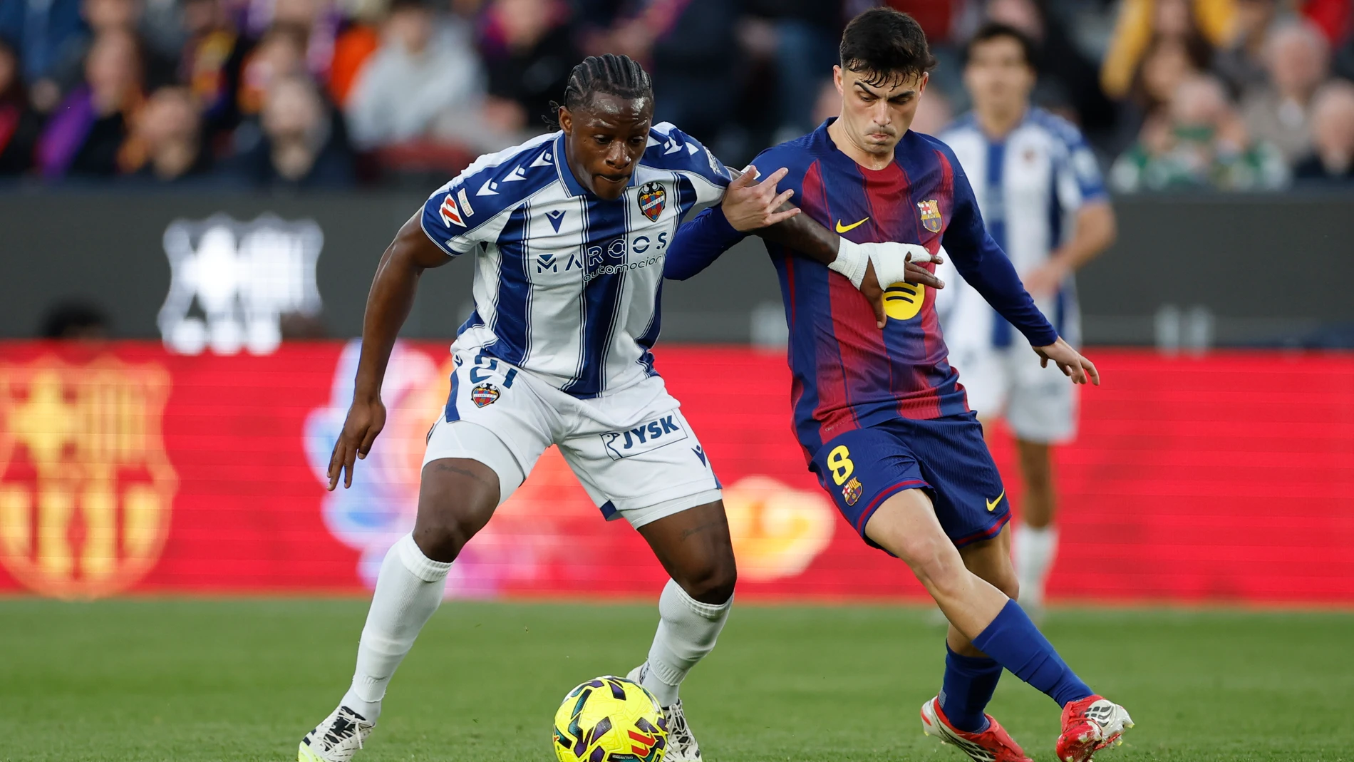 BARCELONA, 22/02/2026.- El centrocampista del FC Barcelona Pedri (c) disputa un balón con el delantero del Levante Etta Eyong (i) durante el partido de la jornada 25 de LaLiga EA Sports que FC Barcelona y el Levante UD disputan este domingo en el Spotify Camp Nou de Barcelona. EFE/ Alberto Estevez