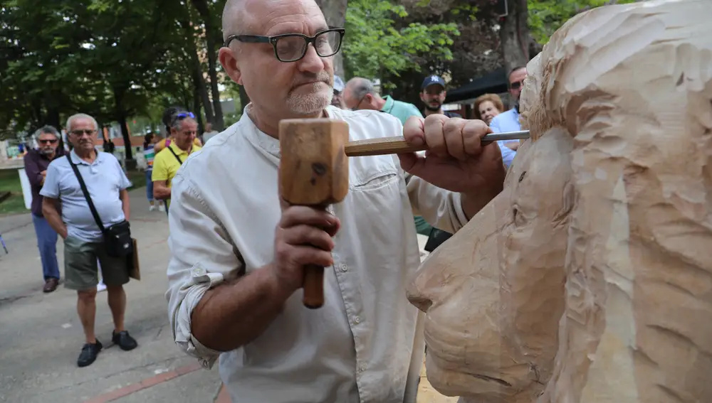 El escultor Alfredo Martín 'Chis' talla la cabeza de un león en el parque de la Huerta de Guacián en el marco de la feria de San AntolínPalencia)