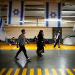 Varias personas se refugian en un estacionamiento subterr&aacute;neo mientras las sirenas de ataque a&eacute;reo advierten del impacto de misiles por parte de Ir&aacute;n, en Tel Aviv