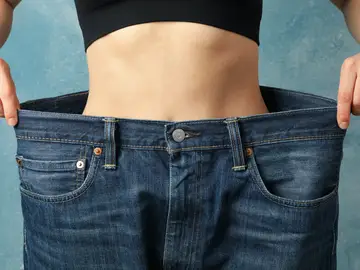 Imagen de archivo de una persona que ha adelgazado y que le quedan grandes sus antiguos pantalones Imagen de archivo de una persona que ha adelgazado y que le quedan grandes sus antiguos pantalones