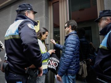El portavoz de la plataforma Derecho al Techo, Jonathan Mesa (2i), trata de mediar con los agentes de la Polic&iacute;a Local durante la ejecuci&oacute;n del desahucio.