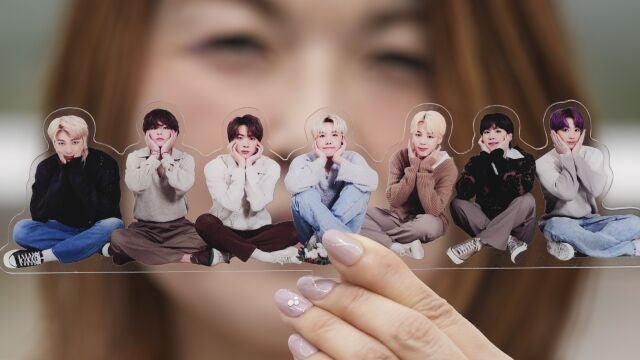 A fan of K-pop band BTS poses with a group photo of BTS during the annual 2025 BTS Festa celebrating the BTS' debut anniversary in Goyang, South Korea, Friday, June 13, 2025.