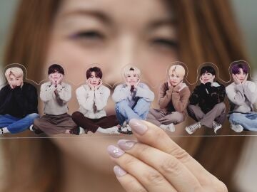 A fan of K-pop band BTS poses with a group photo of BTS during the annual 2025 BTS Festa celebrating the BTS' debut anniversary in Goyang, South Korea, Friday, June 13, 2025.