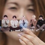 A fan of K-pop band BTS poses with a group photo of BTS during the annual 2025 BTS Festa celebrating the BTS' debut anniversary in Goyang, South Korea, Friday, June 13, 2025.