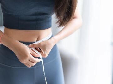 Imagen de archivo de una mujer midi&eacute;ndose el abdomen