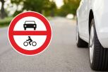 Se&ntilde;al de entrada prohibida a veh&iacute;culos de motor junto a un veh&iacute;culo circulando por carretera