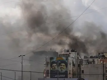 Lebanon Israel Iran War Portraits of Hezbollah's late leaders Hassan Nasrallah, right, and his cousin, Hashem Safieddine, are seen, as smoke rises following an Israeli airstrike in Dahiyeh, Beirut's southern suburbs, Lebanon, Monday, March 30, 2026. (AP Photo/Hassan Ammar)