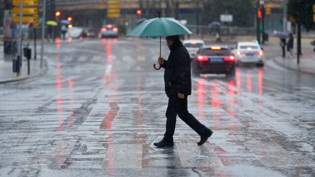M&Aacute;LAGA, 08/04/2026.-Una persona se protege de la lluvia con un paraguas este mi&eacute;rcoles en M&aacute;laga. La influencia de una borrasca aislada -ubicada al suroeste de la pen&iacute;nsula-, con un previsible car&aacute;cter estacionario, dejar&aacute; hoy precipitaciones en el oeste peninsular, especialmente en el cuadrante suroeste, lluvias que podr&aacute;n extenderse a zonas aleda&ntilde;as del centro peninsular, con descenso de temperaturas en algunas zonas y calima en el centro y oeste peninsular.EFE/ Jorge Zapata 
