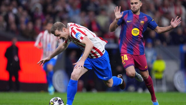 Atletico Madrid's Alexander Sorloth, left, and Barcelona's Eric Garcia challenge for the ball during the Champions League quarterfinal second leg soccer match between Atletico Madrid and Barcelona in Madrid, Spain, Tuesday, April 14, 2026. (AP Photo/Manu Fernandez)