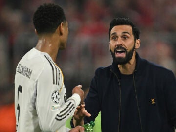 Real Madrid's head coach Alvaro Arbeloa talks with Jude Bellingham during the Champions League quarterfinal second leg soccer match between Bayern Munich and Real Madrid in Munich, Germany, Wednesday, April 15, 2026. (AP Photo/Lennart Preiss)