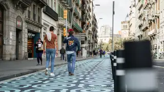 Dos personas caminando por la calle Pelai tras la instalación de las pinturas en el suelo en 2023 Dos personas caminando por la calle Pelai tras la instalación de las pinturas en el suelo en 2023