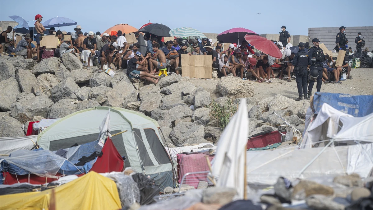 Varios agentes de Policía Nacional controlan a los migrantes en la playa del Trampolín, a 23 de septiembre de 2026, en Ceuta